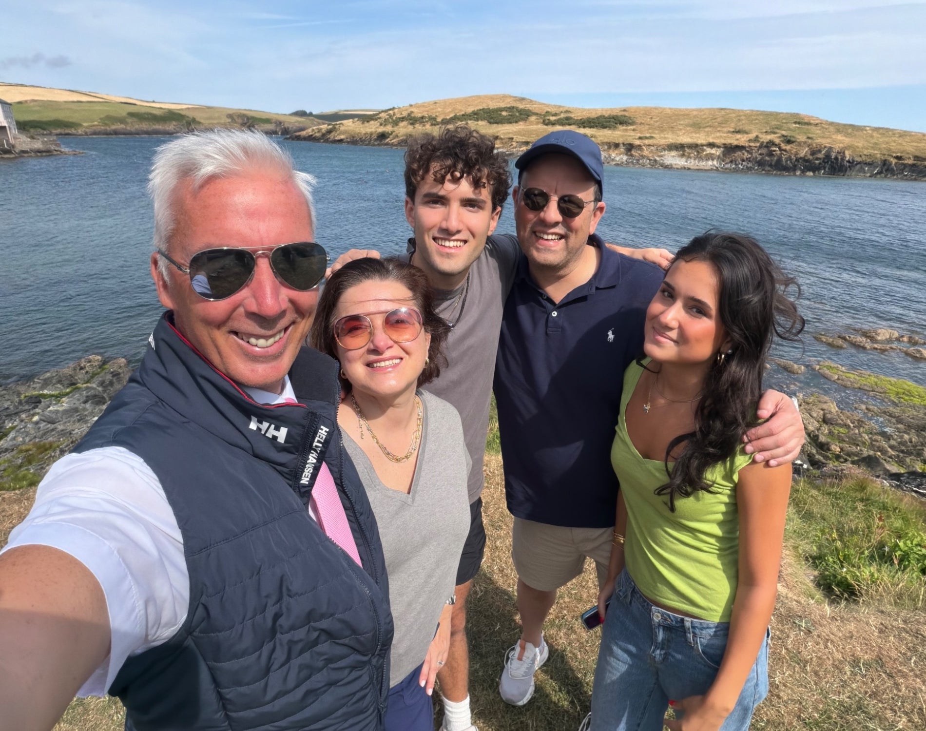 Private Tours Cork driver standing with guests for a photograph by a rocky shoreline