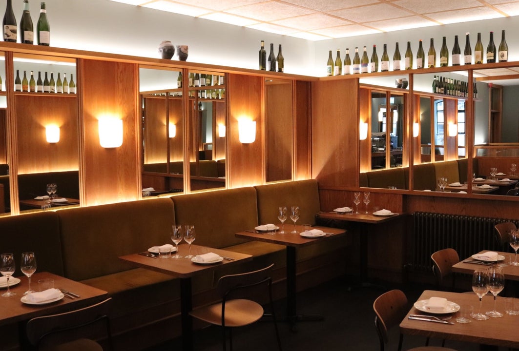 The dining area at Comet with wood panel and mirrors on the walls dim lighting