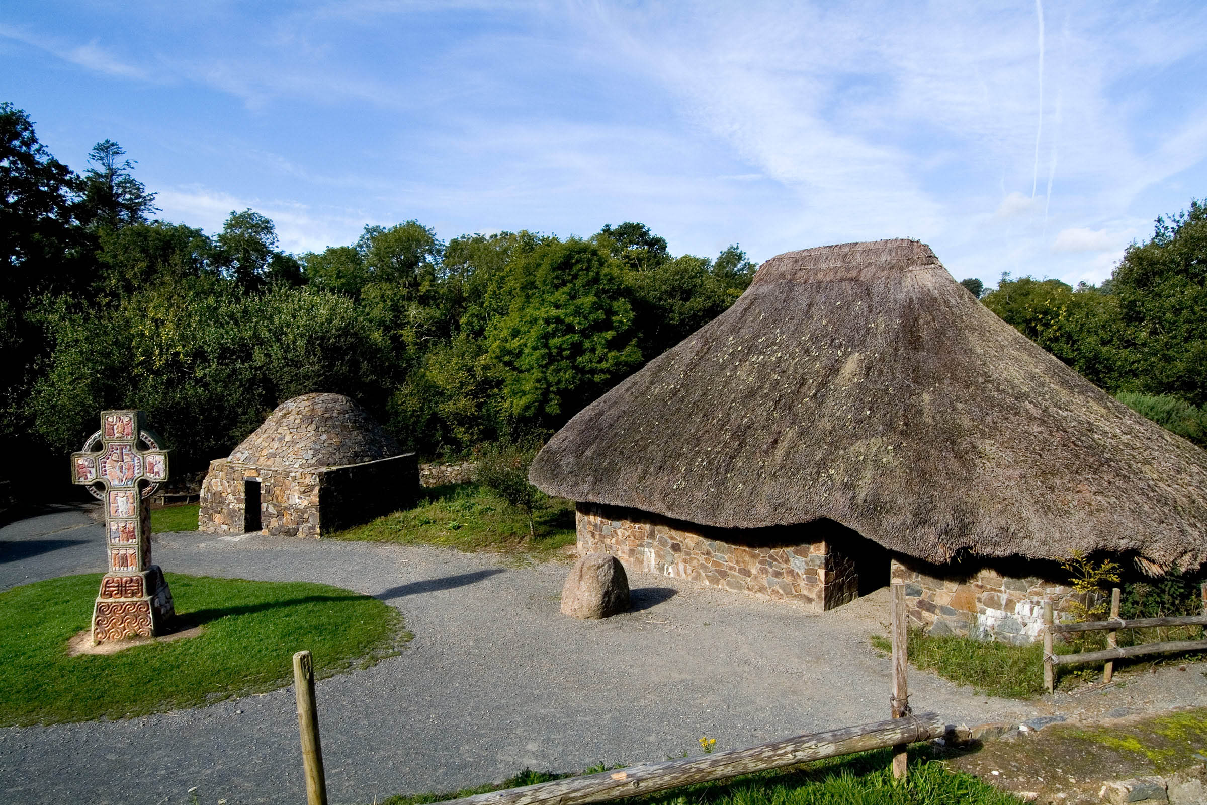 A high cross and ancient stone settlements at the Irish National Heritage Park in County Wexford.