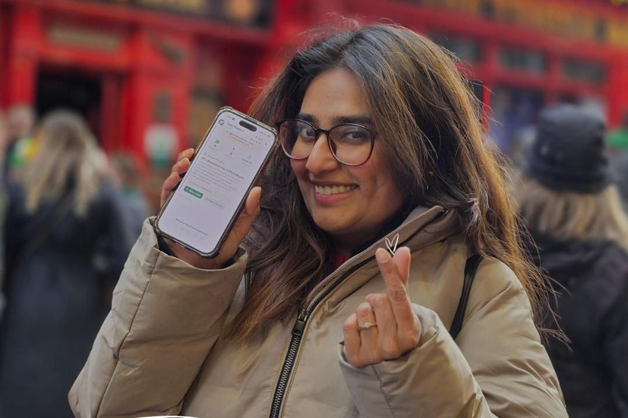 A person holding a phone up so that an app is visible on the screen