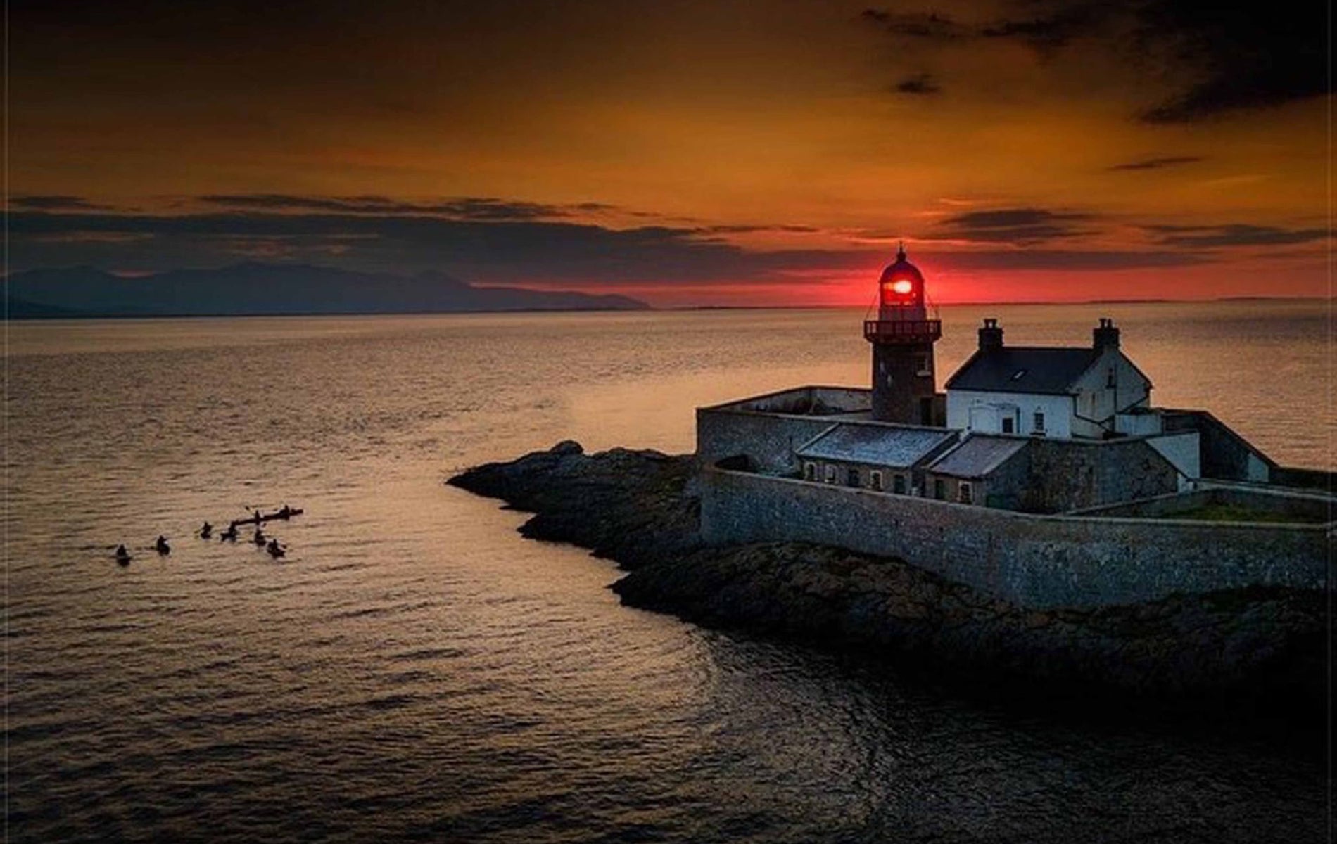 A view of Fenit Lighthouse at sunset with Wild Water Adventures