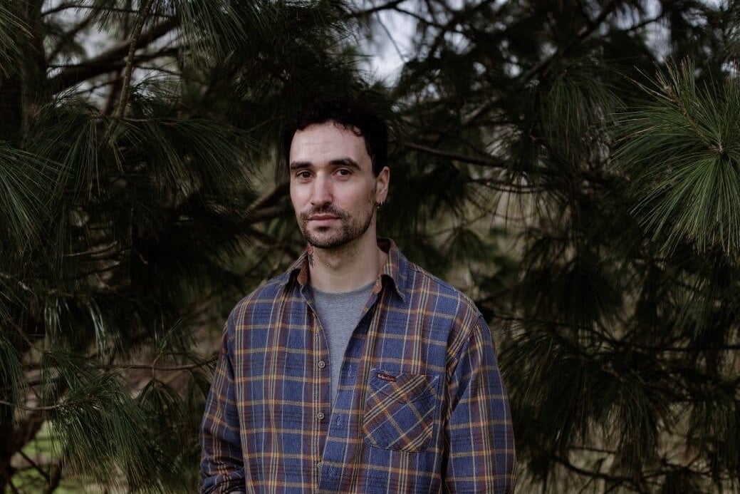 A conversation with Djamel White, a serious looking man in a checked shirt