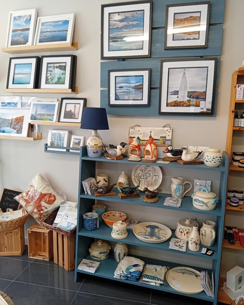 A shop floor display of local prints and pottery at West Cork Crafts