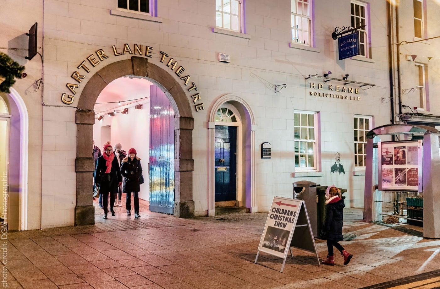 An arched entrance with people coming through it