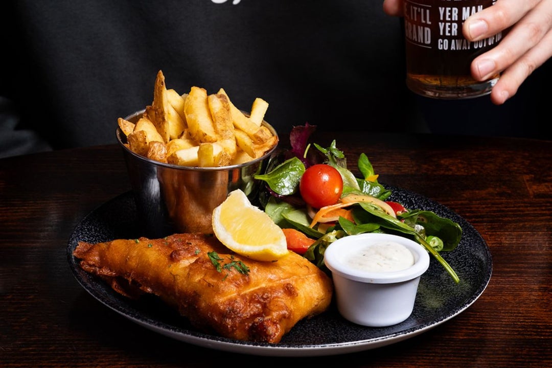 A plate with fish and chips garnished with a salad