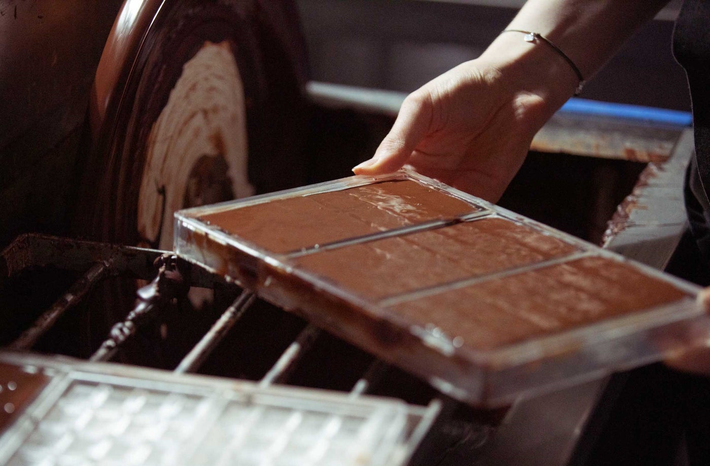 Someone holding a tray of freshly made chocolate bars