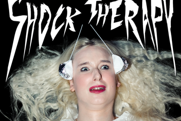 A shocked looking woman with white blonde hair 