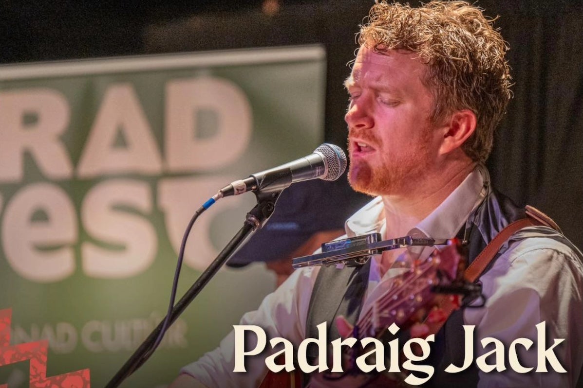 A man playing a guitar singing into a mic