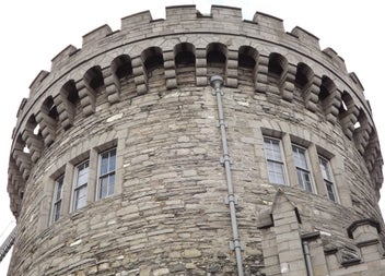 A close up of a stone circular tower that is part of a castle