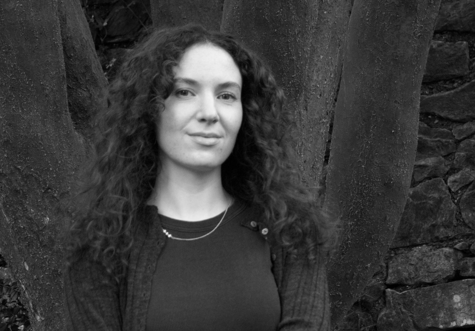 Síomha Callanan: Residency at Triskel Arts Centre, pictured standing in front of large tree trunks