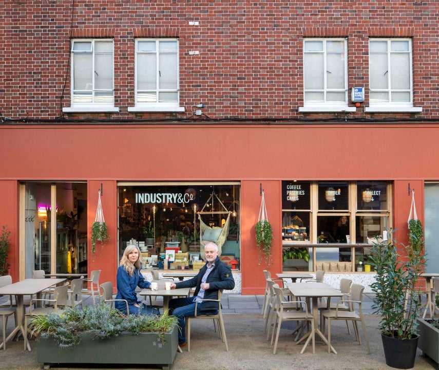 Exterior of a café with a couple sitting at an outdoor table