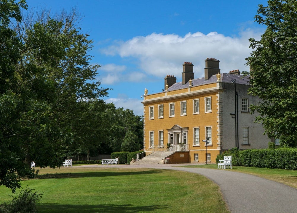 Exterior view of Newbridge House with trees and driveway
