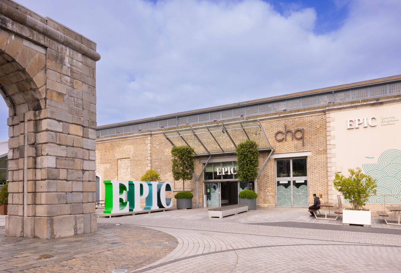 A courtyard entrance to a building with a large business logo outside