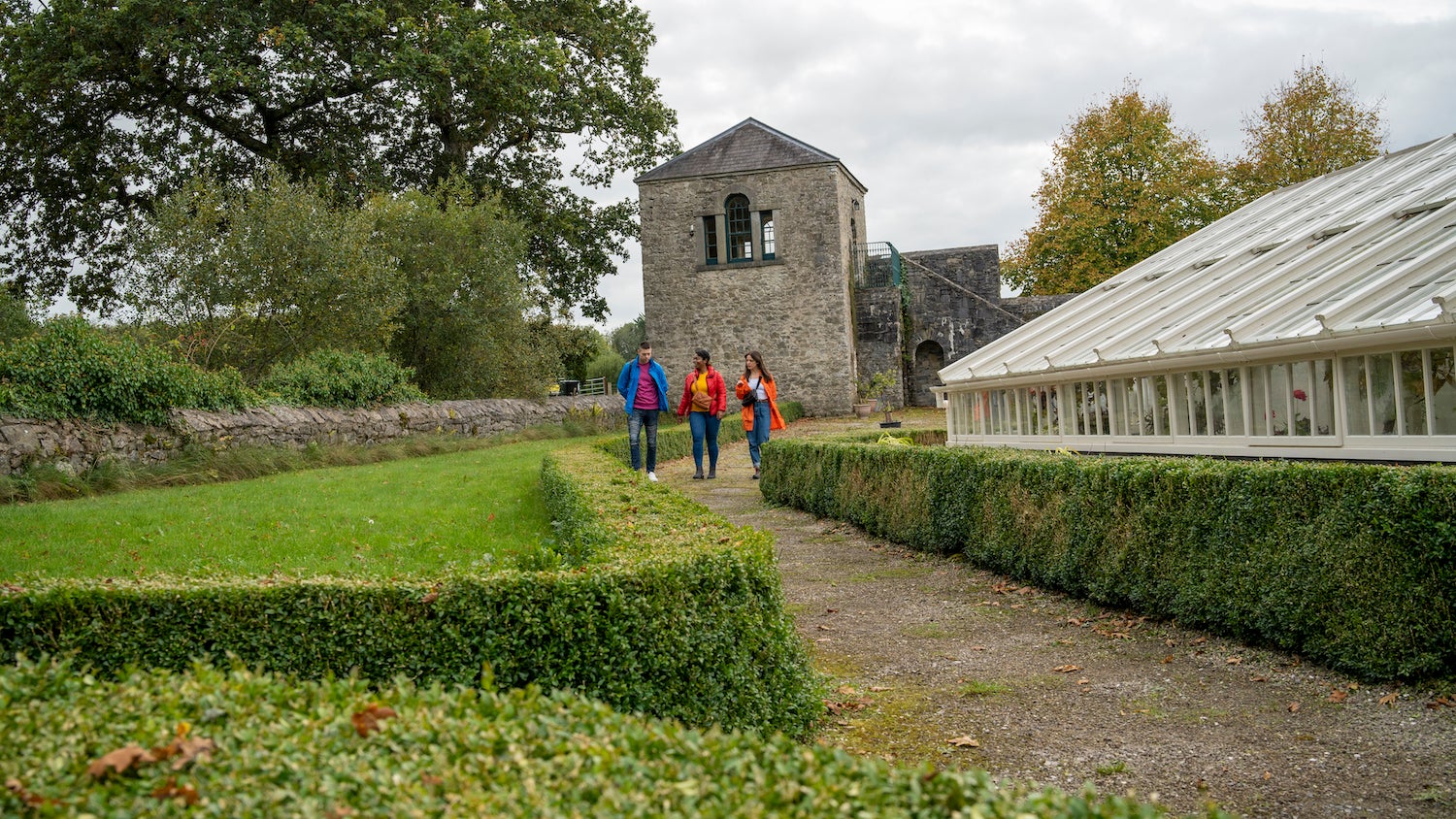 Three people walking through the grounds of Strokestown House and Park in County Roscommon.