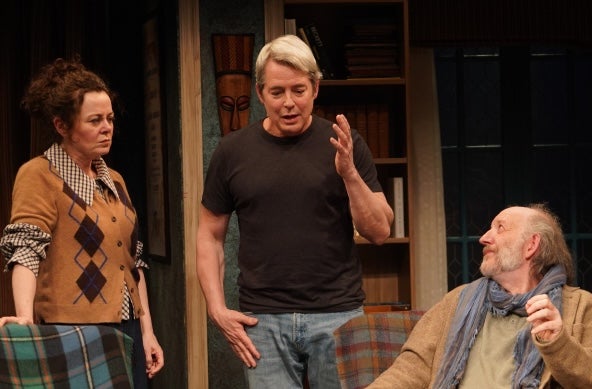 3 people on a stage in a discussion.