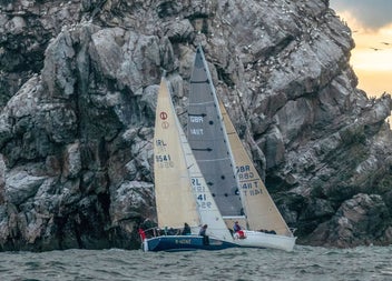 Sailing boat by the sea cliffs