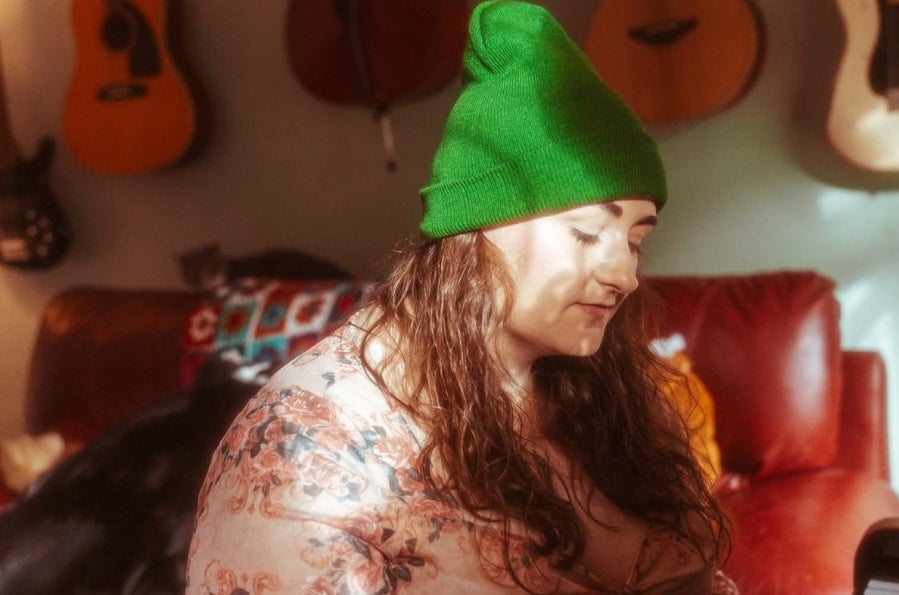A woman in green wooly hat looking downwards.