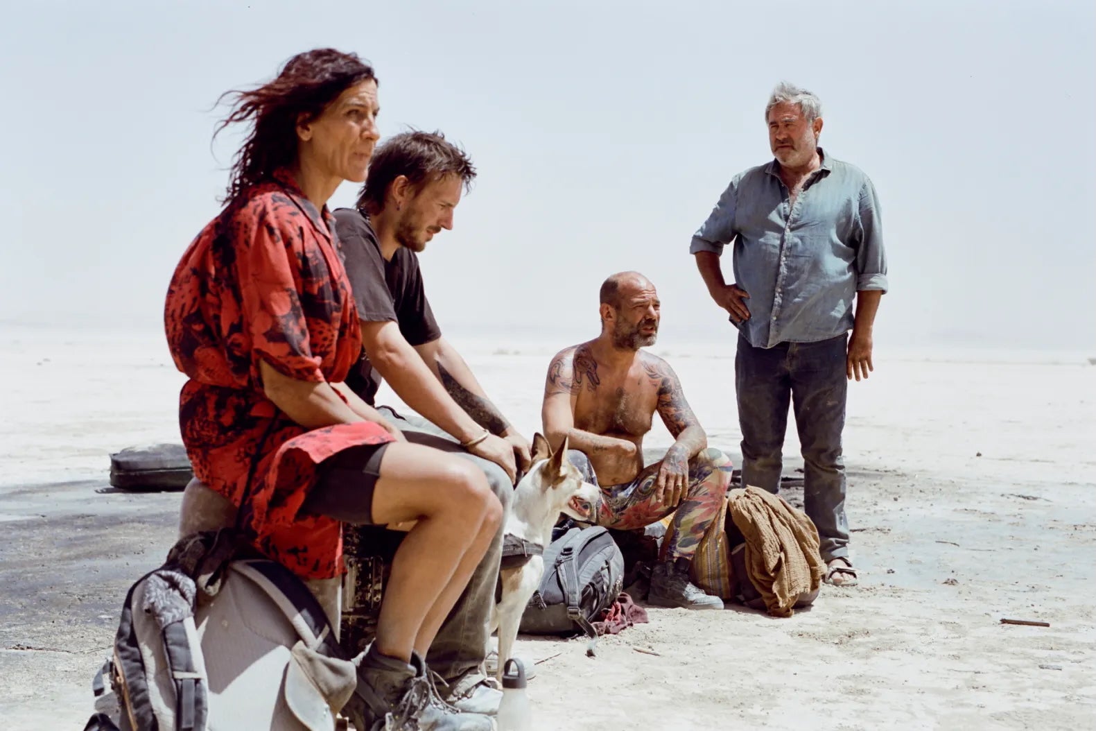 Three men and a woman in a desert.