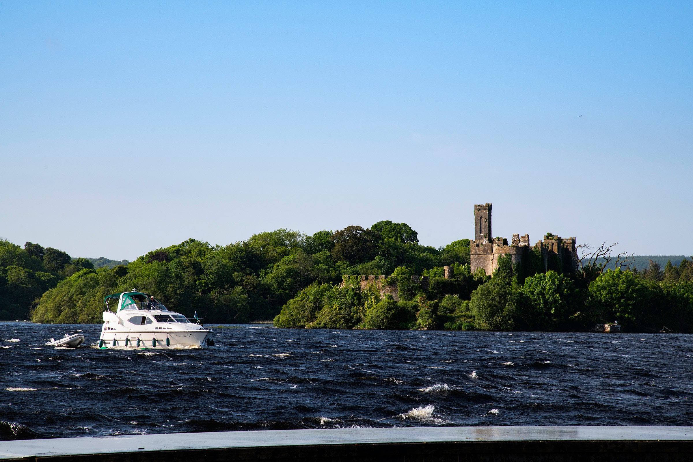 A boat sailing past a castle on Lough Key in Roscommon