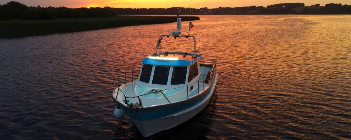 The Hot Tub Boat cruising the river with the sunset in the back ground
