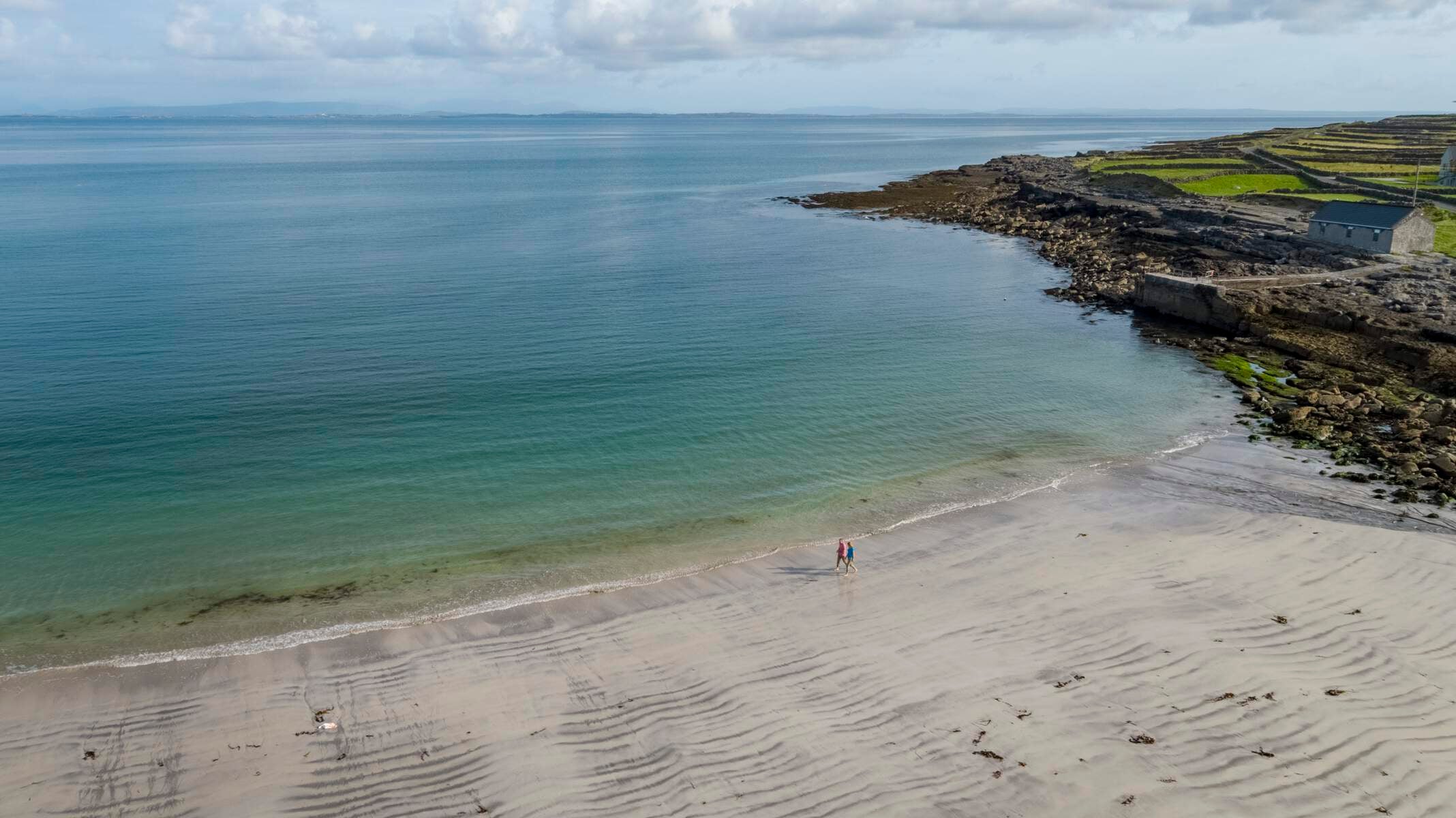 Couple walking on Kilmurvey Beach, Inishmore, Aran Islands, County Galway
