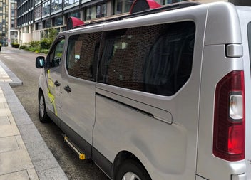 A silver van parked along a street kerb