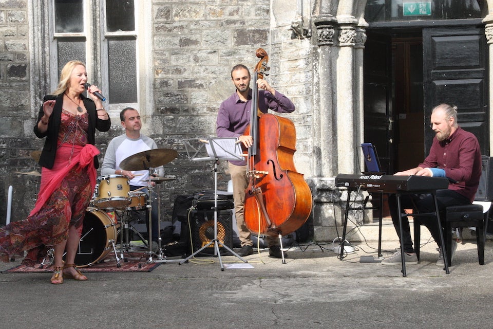 Small group of musicians performing in front of an old front door
