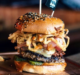 Gourmet burger topped with cheese bacon and crispy onions