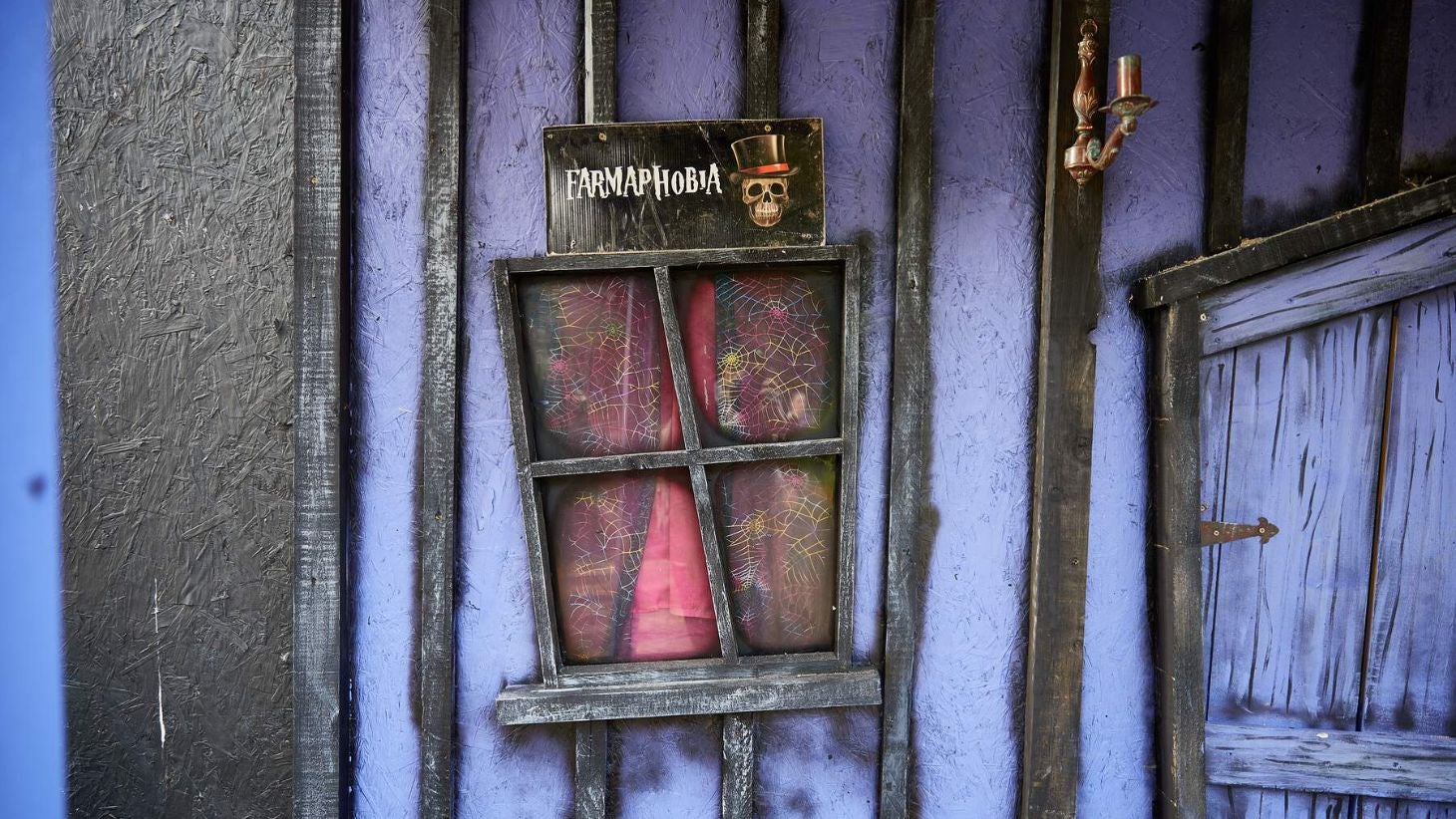 A sign at Causey Farm that says Farmaphobia with purple and black stripes and a skull with a top hat.