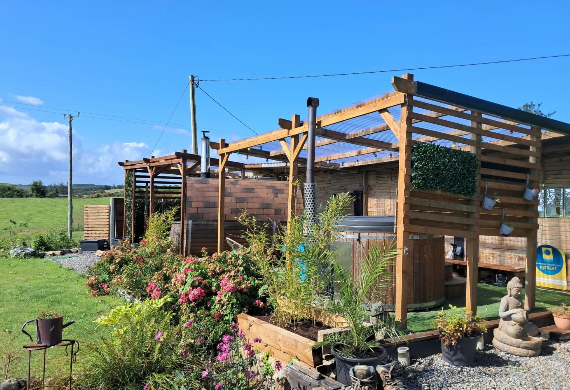 View of an outdoor hot tub and hydrotherapy tub housed within a timber wellness structure