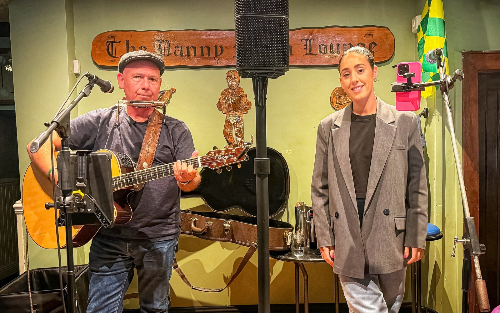 A guitar player and singer on a stage ready to perform