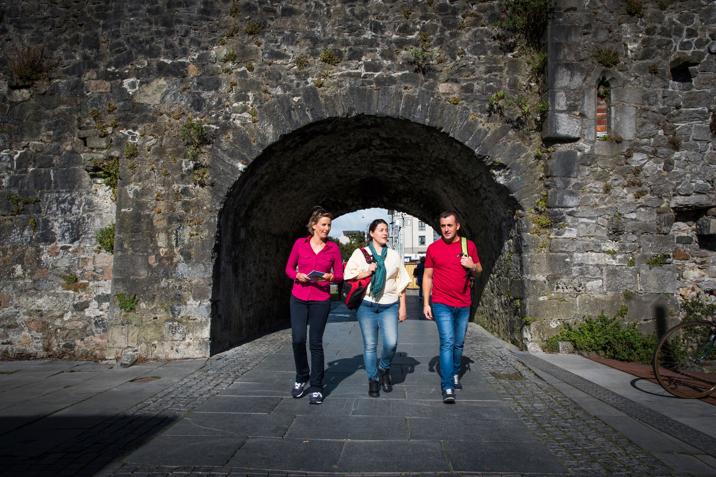 Friends walking through the Spanish Arch, Galway City