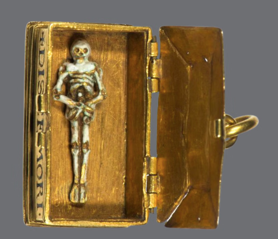 Shadows of Samhain Halloween. A small figure of a skeleton in an old gold box.