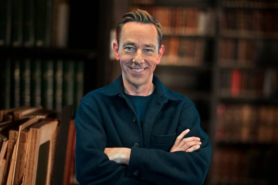 A smiling man with crossed arms