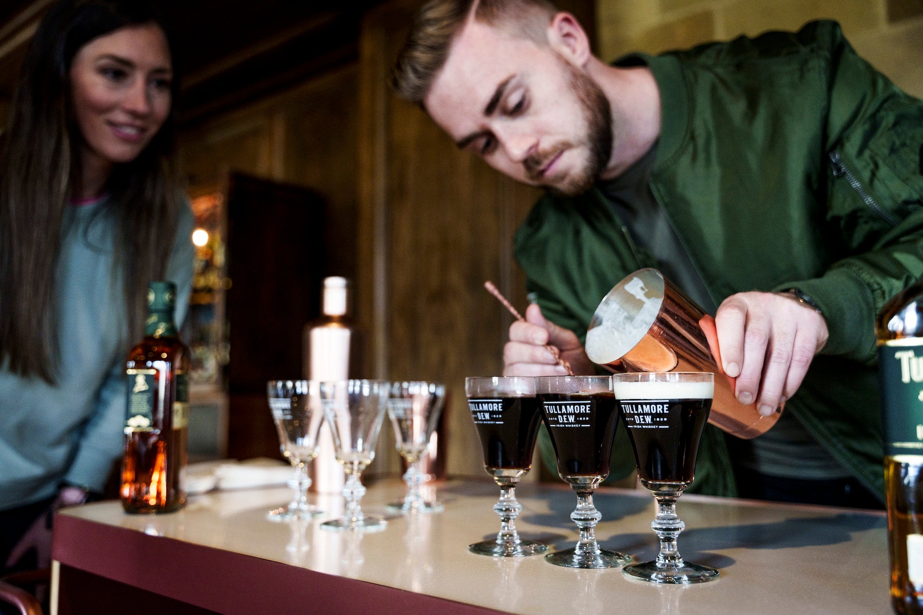 A man powering an Irish Coffee using Tullamore Dew.