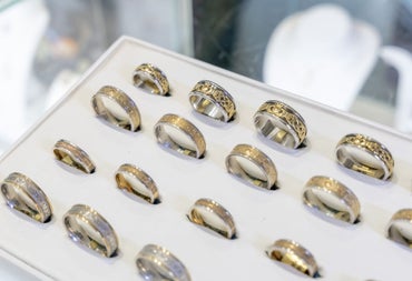 A display case with gold and silver Celtic rings