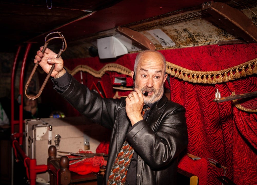 A bus tour guide giving a ghost tour on a bus