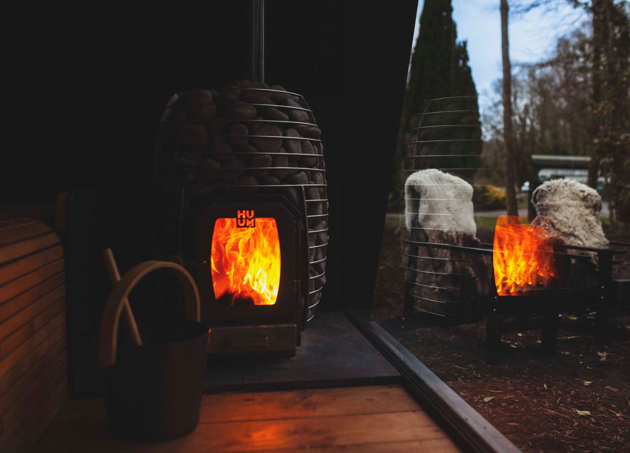 Fire for the sauna with bright flames reflected in the window