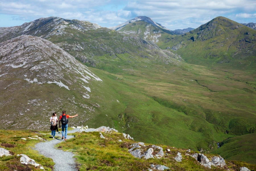 Couple walking with mountains facing them