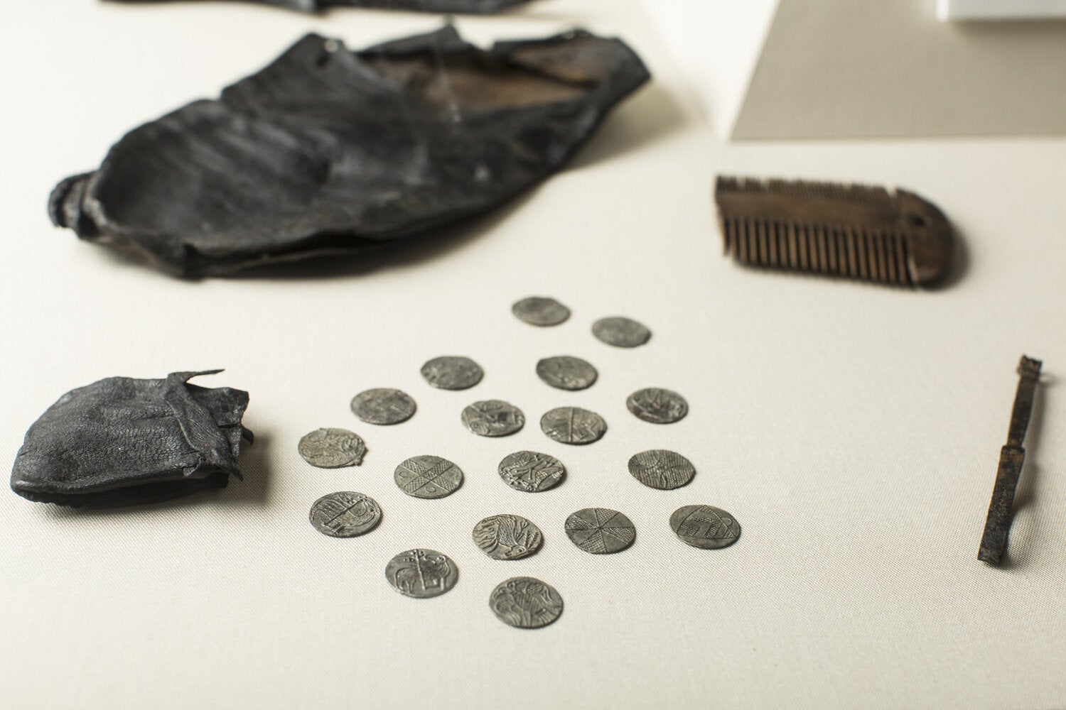 Viking coins spread over a tables from a leather pouch