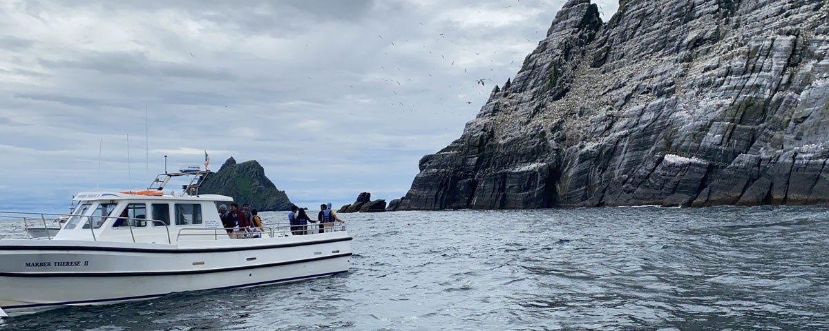 The Skellig Michael Cruises Boat on the sea beside the craggy rocks of Skellig Michael