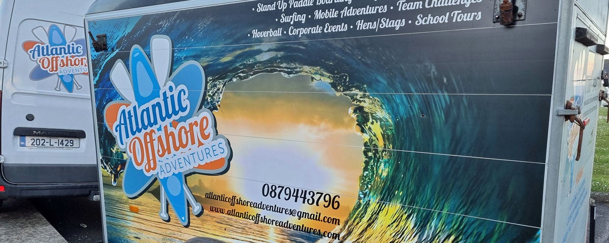 Trailer attached to a van showing logo and contact number for Atlantic Offshore Adventures