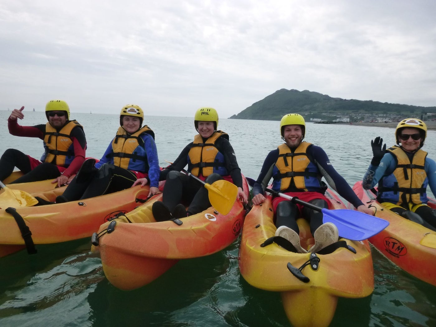 Five people in kayaks lined up side by side