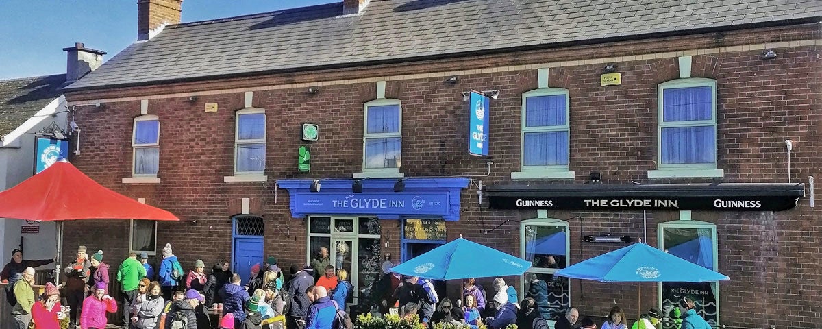 The Glyde Inn Beachside Bar & Restaurant exterior with umbrellas and people
