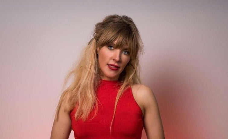 Comedian Aideen McQueen, a woman in red dress holding a mic