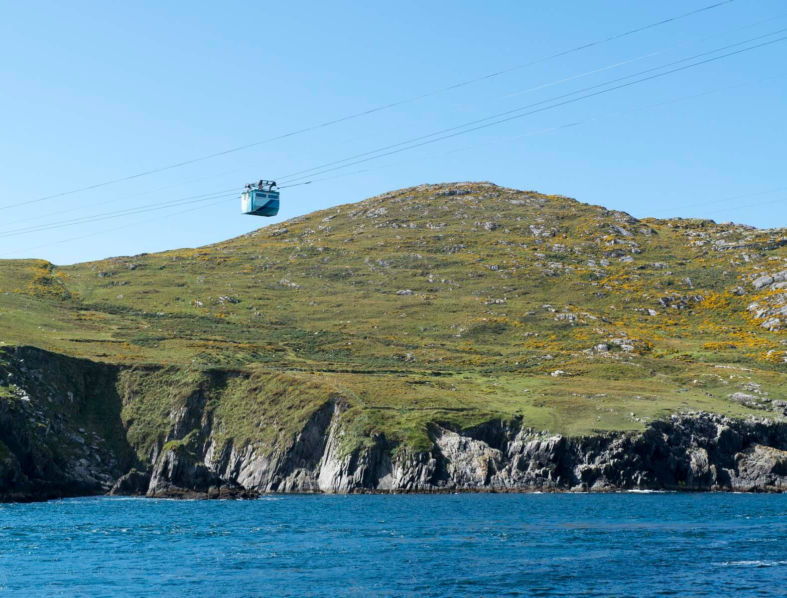 Cable car with land in the background and sea underneath