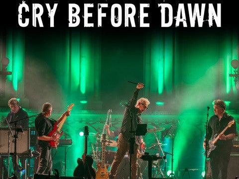 A band performing in stage with green lighting