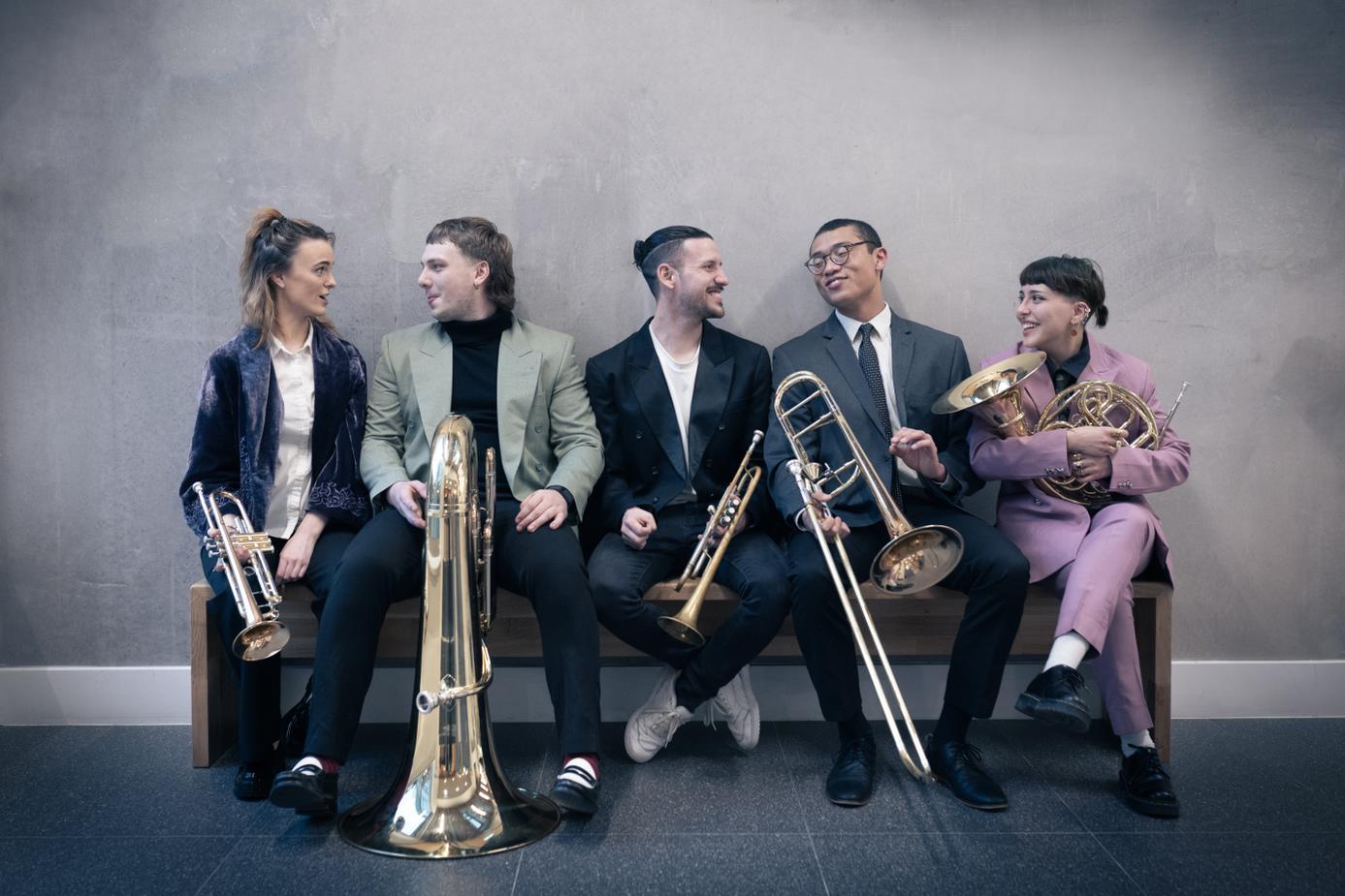 5 young brass musicians with their instruments