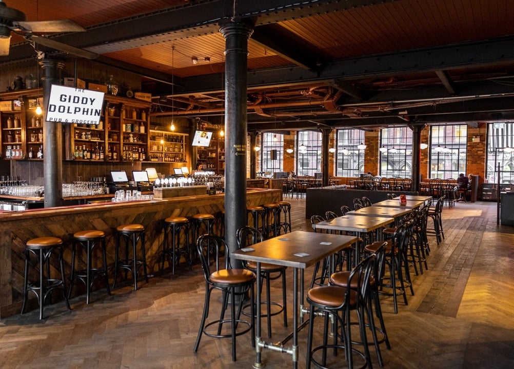 Interior of a bar with wooden counter, tables and seats