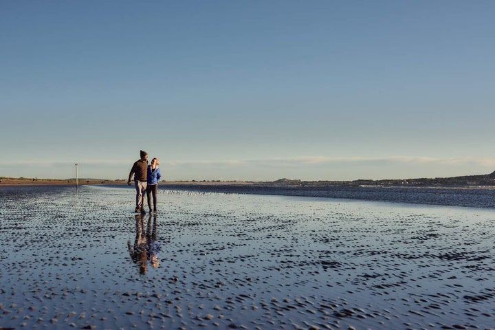 Couple walking on the beach at Bull Island, Dublin City, County Dublin